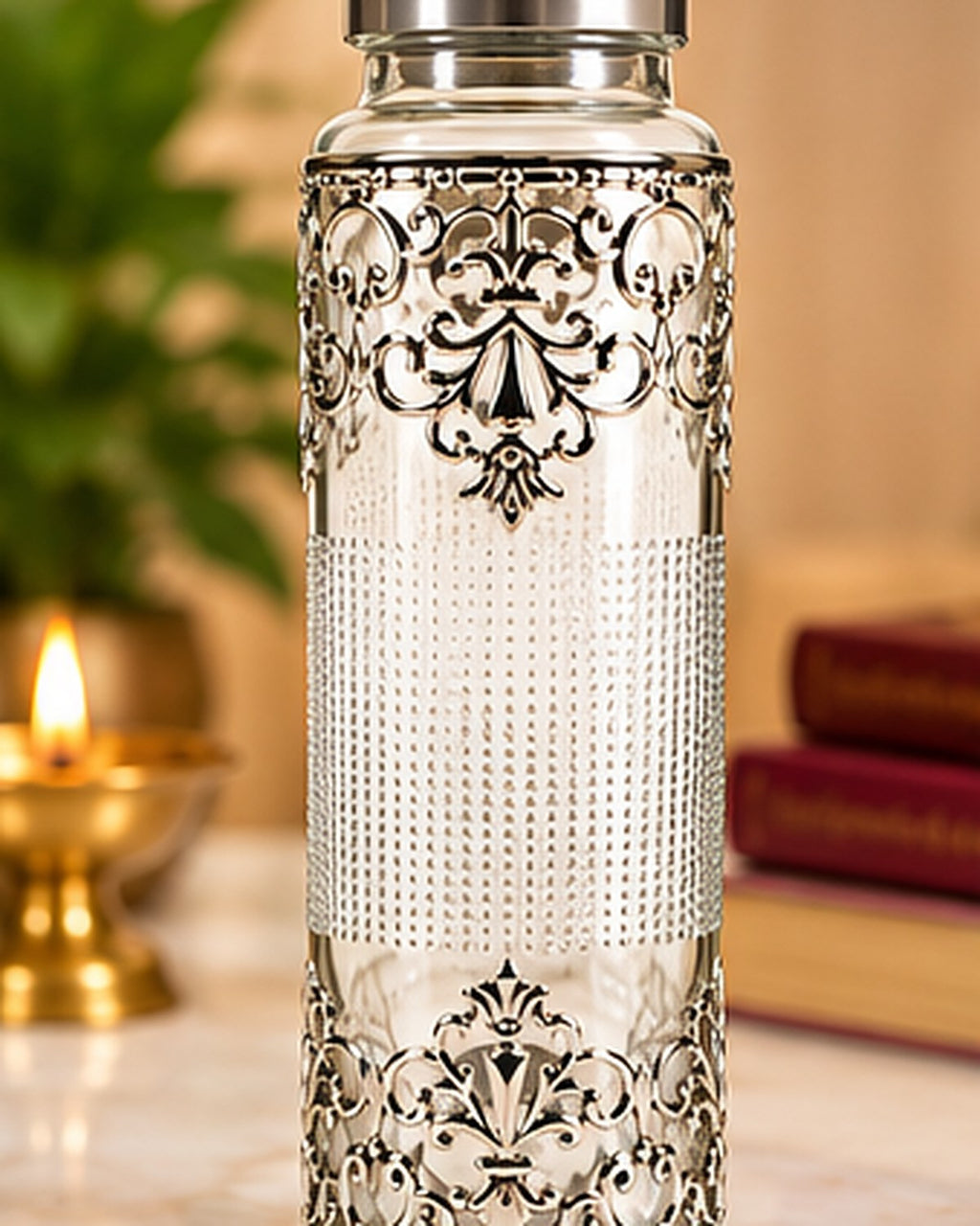 German Silver filigree glass water bottle standing on marble beside a lit diya