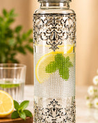 Filigree glass water bottle filled with lemon and mint water, glass alongside
