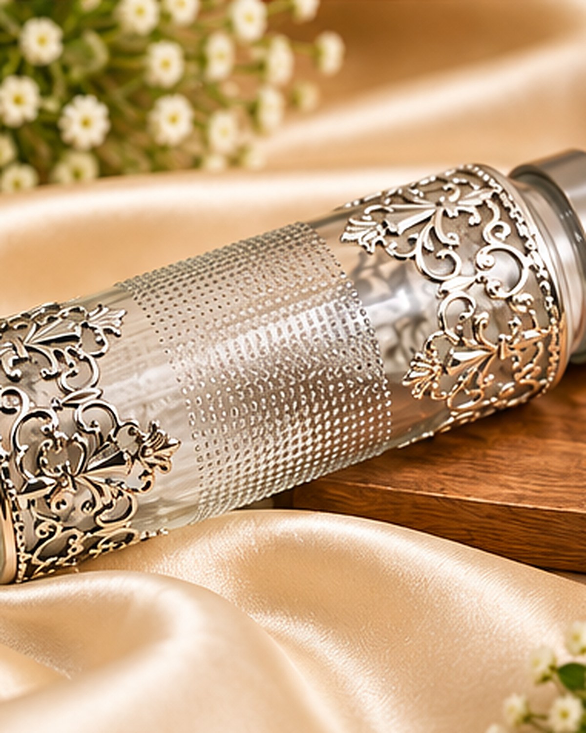 Filigree water bottle lying on gold satin, showing the full German Silver sleeve