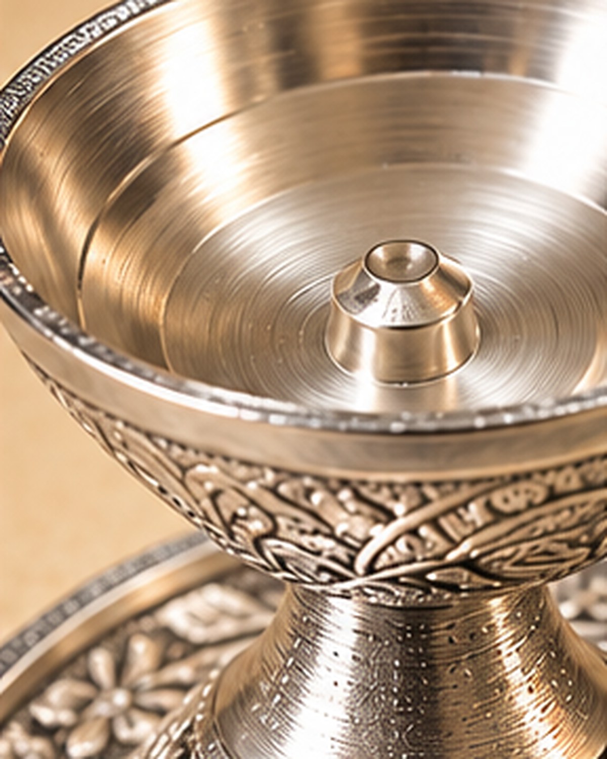 The polished well of the chirag with the turned pin that holds the batti upright