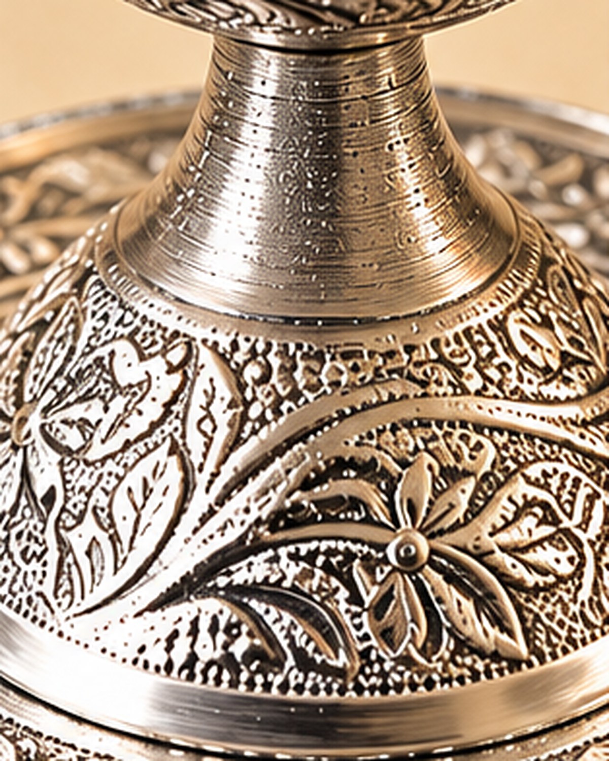 Hand-chased floral work on the pedestal foot of the chirag