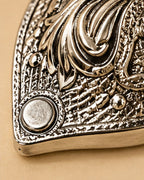 Close view of the chased lid and the plain set stone at its tip